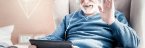 Senior citizen using tablet technology and headphones