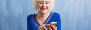 Senior lady in blue using a smartphone