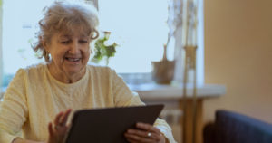 Senior lady smiling using a tablet